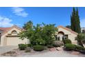 Charming single-Gathering home featuring a two-car garage, desert landscaping, and a well-maintained front yard at 2633 Legend Dr, Las Vegas, NV 89134