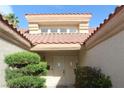 Front entryway with neutral-toned double doors, tiled roof and mature landscaping at 2633 Legend Dr, Las Vegas, NV 89134