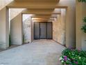 Stunning front entrance featuring travertine, a gated door, and vibrant floral accents at 28 Painted Feather Way, Las Vegas, NV 89135