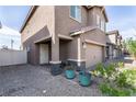 Home exterior featuring a charming entrance with potted plants, brick accents, and a two-car garage at 3553 Judson Ave, Las Vegas, NV 89115
