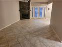 Open-concept living room featuring tile floors, a marble fireplace, and French doors leading to the backyard at 3621 Laguna Verde Way, Las Vegas, NV 89121