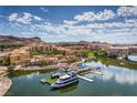 Beautiful aerial view of a lakeside community with Mediterranean-style buildings, a boat launch, and mountain scenery at 56 Tatahatso Point St, Henderson, NV 89011