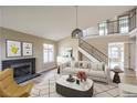 Bright living room features modern decor, high ceilings, a cozy fireplace, and staircase to the upper level at 5629 Caladonia Ave, Las Vegas, NV 89110