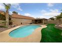 Backyard oasis featuring a sparkling blue pool, covered patio, and lush landscaping, perfect for relaxation at 619 Ancient Mayan Dr, Henderson, NV 89015