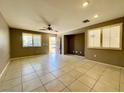 Spacious living room with neutral paint, tile flooring, and abundant natural light from the shuttered windows at 7173 Dravite Ct, Las Vegas, NV 89148