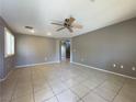 Open living room with tile flooring, ceiling fan, and access to staircase at 7173 Dravite Ct, Las Vegas, NV 89148