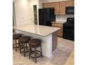 Open kitchen with granite countertops, wooden cabinets and black appliances at 8111 Switchback Run St, Las Vegas, NV 89166