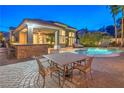 Expansive backyard with a pool, spa, outdoor kitchen, and dining area, creating an ideal entertainment space at 8808 Rozetta Ct, Las Vegas, NV 89134