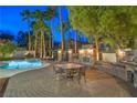 Outdoor space featuring dining area with stone fireplace, built-in grill and beautifully designed brick patio at 8808 Rozetta Ct, Las Vegas, NV 89134