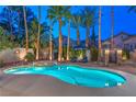 Sparkling pool and spa surrounded by lush palm trees and sun loungers, creating a private backyard oasis at 8808 Rozetta Ct, Las Vegas, NV 89134