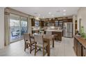 Bright kitchen and dining area with stainless steel appliances and sliding glass door to outdoor living space at 8992 Sparkling River Ct, Las Vegas, NV 89178