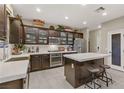 Modern kitchen with dark wood cabinetry, stainless steel appliances, and a center island with seating at 8992 Sparkling River Ct, Las Vegas, NV 89178
