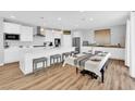 Open-concept kitchen and dining area with white cabinets and wood flooring at 9212 Lunar Effect St, Las Vegas, NV 89143
