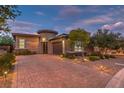 Beautiful home exterior featuring professional landscaping, brick driveway and tasteful outdoor lighting at 9928 Regency Square Ave, Las Vegas, NV 89148