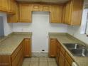 Functional kitchen featuring wooden cabinets, light countertops, and a stainless steel sink at 1675 Jupiter Ct # C, Las Vegas, NV 89119