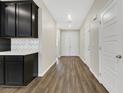 Inviting hallway with wood-look floors leading to double doors and white trim throughout at 234 Polaris Ridge Ave, Henderson, NV 89011