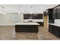 Modern kitchen featuring an oversized island, dark cabinets, and stainless steel appliances at 234 Polaris Ridge Ave, Henderson, NV 89011