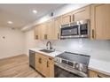 Well-equipped kitchen with stainless steel appliances, wood cabinets, and quartz countertops at 2606 S Durango Dr # 117, Las Vegas, NV 89117
