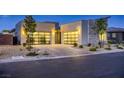 Striking modern home showcases a three-car garage, elegant stone details, and desert-friendly landscaping at 2910 Raywood Ash Dr, Las Vegas, NV 89138