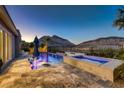 Inviting pool and spa with lounge chairs, lush landscaping, and mountain views for ultimate relaxation at 2910 Raywood Ash Dr, Las Vegas, NV 89138