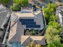 Aerial view of a home with a tile roof, solar panels, a rooftop deck, and an outdoor seating area at 2964 Via Della Amore, Henderson, NV 89052