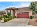 Single-story home with tile roof, desert landscaping, and a two-car garage with a row of windows at 3200 Ridgecliff St, Las Vegas, NV 89129