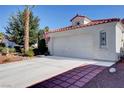 Side view of a home with a tile roof, showing the driveway leading to the attached two-car garage at 3913 Cutting Horse Ave, North Las Vegas, NV 89032