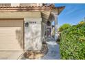Shot of front of house highlighting the two car garage, stucco siding, desert landscaping and front door at 5044 Signal Dr, Las Vegas, NV 89130
