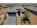Charming single-story home with a paved driveway, complemented by a landscaped front yard and desert surroundings at 54 Mirage View Dr, Henderson, NV 89011