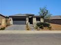 Inviting single-level house with a modern design, desert landscaping, and attached garage at 54 Mirage View Dr, Henderson, NV 89011
