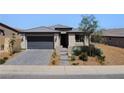Charming single-story home with a well-kept lawn, desert landscaping, and a two-car garage at 54 Mirage View Dr, Henderson, NV 89011