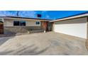 Exterior view of home and driveway with a charming pink front door and attached garage at 5904 Apple Valley Ln, Las Vegas, NV 89108