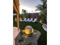 Charming backyard featuring four white lounge chairs and decorative accent lights surrounded by desert landscaping at 6316 Bluejay Way, Las Vegas, NV 89146