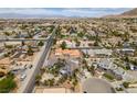 Aerial view showcases a neighborhood with various home styles, mature trees, and mountain views in the distance at 6520 Turtle Hill Rd, Las Vegas, NV 89110