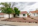 Attractive single-level home with red rock landscaping, mature trees, and a tile roof at 709 Heritage Point Dr, Henderson, NV 89002