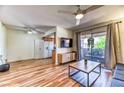 Bright living room featuring wood floors, a ceiling fan, and access to the kitchen at 7200 Pirates Cove Rd # 2071, Las Vegas, NV 89145