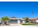Single-story home with a well-manicured lawn, desert landscaping, and a gray two-car garage door at 4012 Mira Ln, Las Vegas, NV 89108
