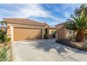 Spacious two-car garage and separate single-car garage with long driveway and mature landscaping at 2489 Black River Falls Dr, Henderson, NV 89044