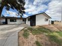View of a single-story house with a white siding and a black accent wall and a lawn at 4186 Toronto Cir, Las Vegas, NV 89121