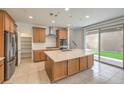 Bright kitchen features an island, stainless steel appliances, and sliding door access to the outdoor space at 89 Oratorio Dr, Henderson, NV 89015