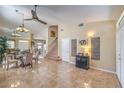Open-concept living room with tile flooring, neutral walls, a ceiling fan, and a staircase at 8942 Galena Crossing St, Las Vegas, NV 89123