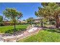 Beautiful community park with picnic benches, barbecue grills, mature trees, and manicured landscaping at 8942 Galena Crossing St, Las Vegas, NV 89123