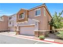 Stylish two-story townhome showcasing a stucco exterior, two-car garage, and desert-friendly landscaping at 9981 Sable Point St, Las Vegas, NV 89178