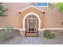 Inviting front entrance with a decorative security gate and desert landscaping at 9981 Sable Point St, Las Vegas, NV 89178