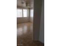 Bright living room featuring tile floors, a ceiling fan, and large windows at 1003 Dover Glen Dr, North Las Vegas, NV 89031