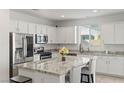 Modern kitchen with white cabinets, stainless steel appliances, granite countertops, and a center island with seating at 10468 Skye Knoll Ave, Las Vegas, NV 89166