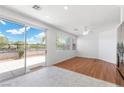 Bright living room with wood floors, sliding glass doors to patio, ceiling fan, and neutral paint at 1524 Remembrance Hill St, Las Vegas, NV 89144