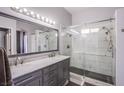 Modern bathroom with a double sink vanity, a large mirror and a walk-in shower with glass doors at 1552 Livingston Dr, Henderson, NV 89012
