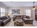 Comfortable living area featuring tile floors, a sectional sofa, plantation shutters, and a curated gallery wall at 1552 Livingston Dr, Henderson, NV 89012