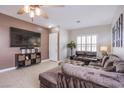 Spacious living room with a large sectional sofa, plantation shutters, and a mounted television at 1552 Livingston Dr, Henderson, NV 89012